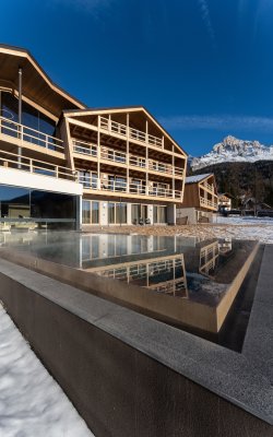 Hotel con infinity pool e paesaggio invernale innevato