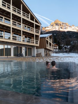 Couple in warm infinity pool with mountain view