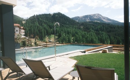Außenpool mit Liegen und Bergblick in ruhiger Natur.