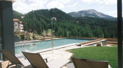 Außenpool mit Liegen und Bergblick in ruhiger Natur.