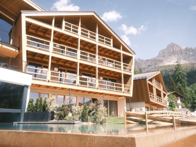 Moderne Hotelanlage mit Außenpool und Bergpanorama.