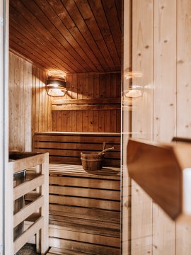 Gemütliche Sauna mit Holzbänken und Aufgusseimer