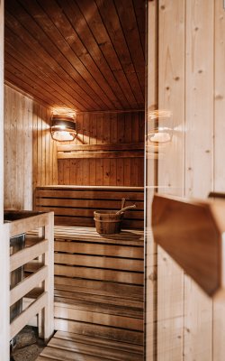 Gemütliche Sauna mit Holzbänken und Aufgusseimer