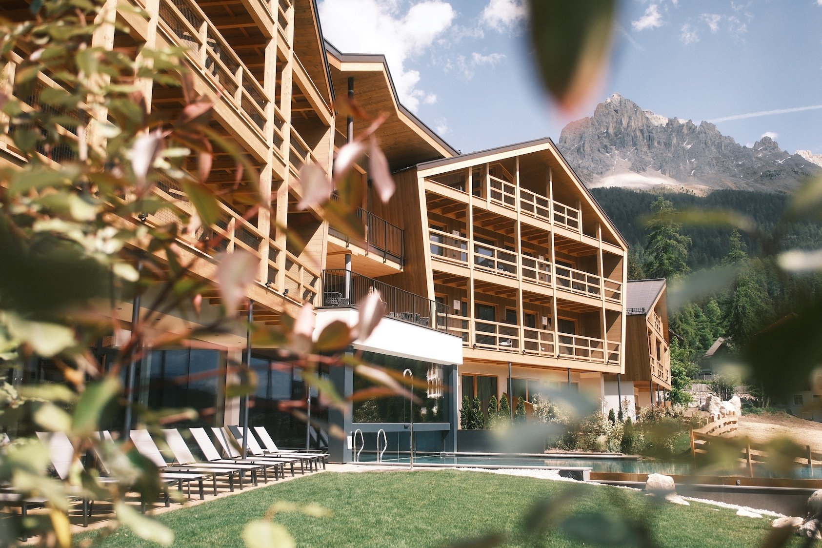 Hotelanlage mit Bergblick und Außenpool in sonniger Lage.