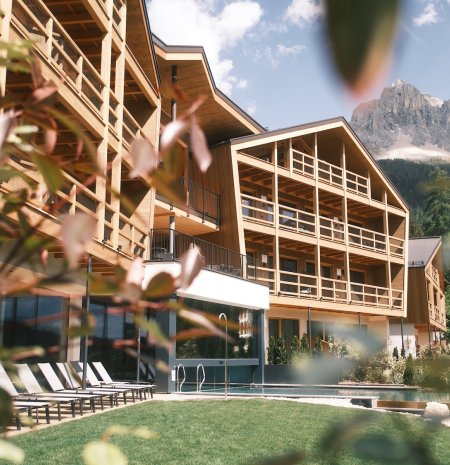 Hotelanlage mit Bergblick und Außenpool in sonniger Lage.