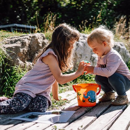 Due bambini giocano sul pontile con secchiello arancione