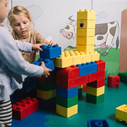 Bambini costruiscono giraffa colorata con mattoncini grandi