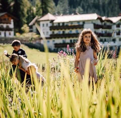 Mädchen vor dem Teich, andere Kinder forschen im Hintergrund