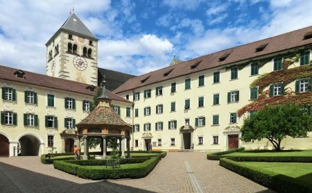 Klosterhof mit Brunnen, Uhrturm und gepflegter Gartenanlage