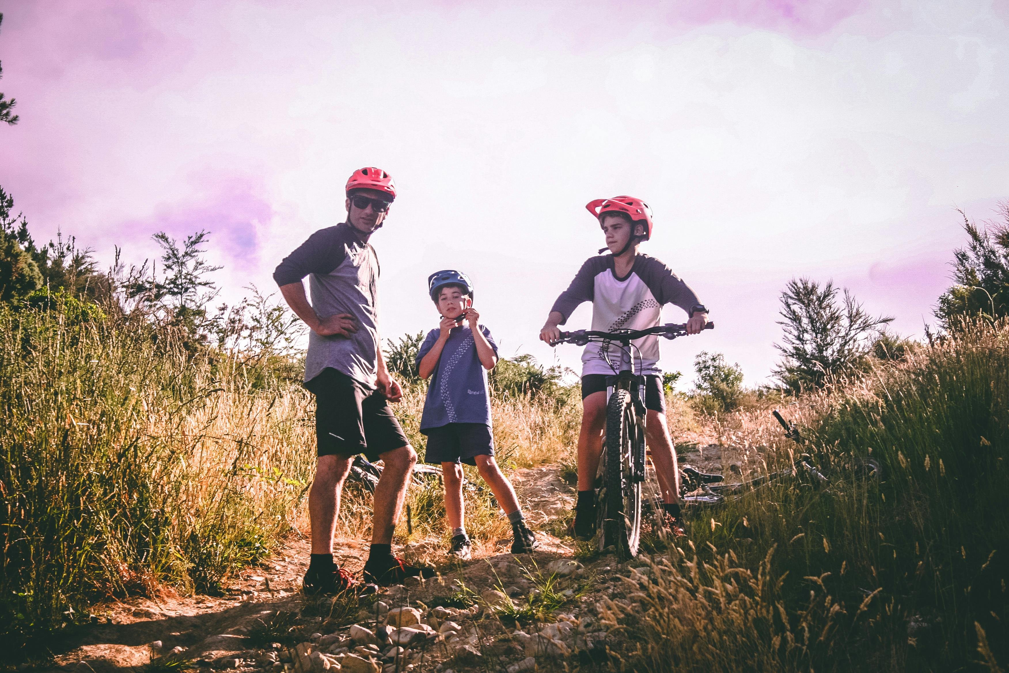 Familie mit Fahrrädern und Helmen auf steinigem Naturweg