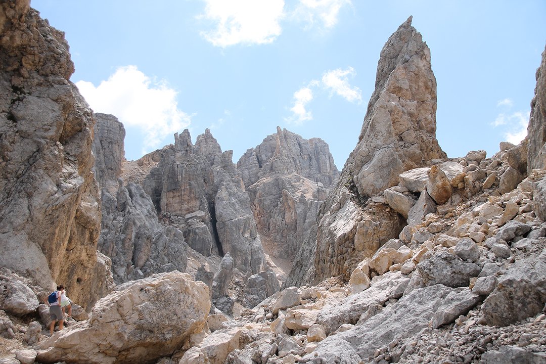 Wanderer zwischen Felsen in einer Dolomitenschlucht