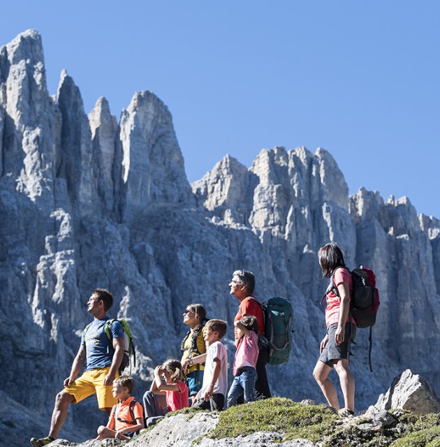 Famiglia in escursione davanti alle cime rocciose