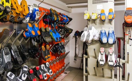 Skischuhe und Skistiefel ordentlich an der Wand im Skiraum aufgehängt.