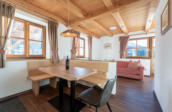Gemütliche Essecke mit Holzbank, Stuhl und Sofa im Wohnzimmer