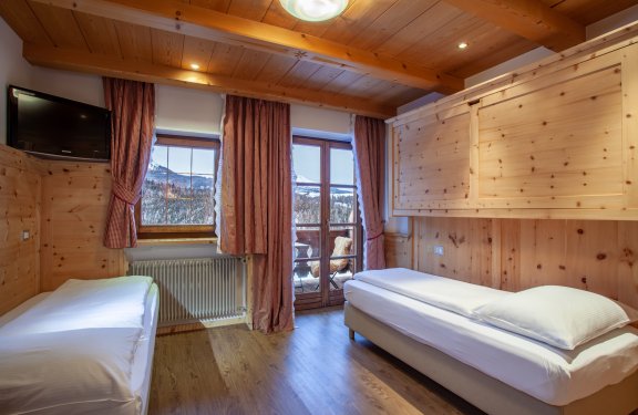 Kleines Zimmer mit zwei Einzelbetten, Balkon und Holzverkleidung