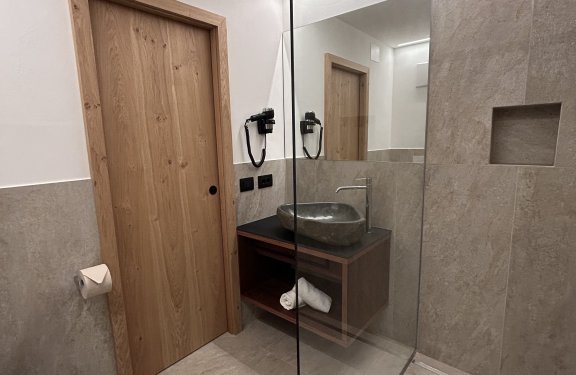 Moderne Dusche mit Holz-Tür und Steinwaschbecken, Handtuchablage
