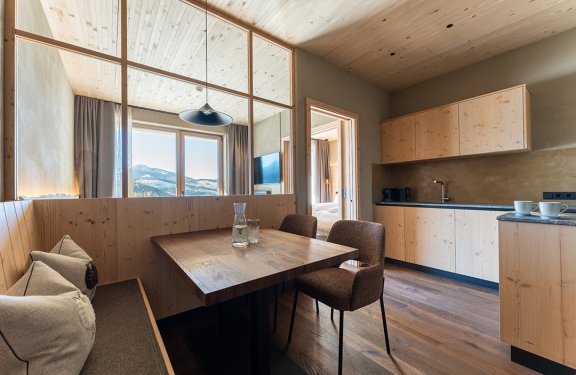Cozy dining area with wooden table, chairs, and mountain view through window
